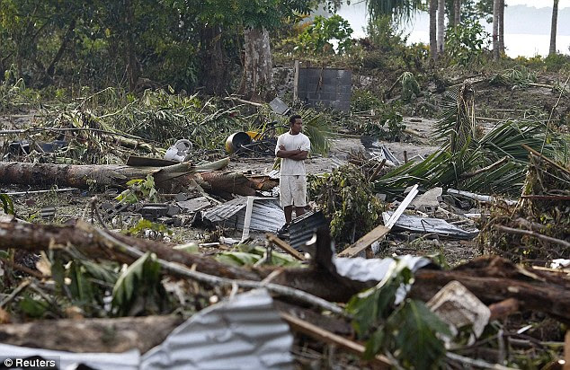 A man pauses to survey the destruction in tsunami destroyed Maninoa Siumu on the southern coast of Western Samoa 