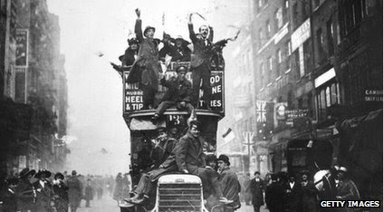 People waving flags from a London bus to celebrate the end of the war