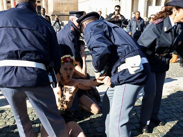 Ativista do Femen é detida por policiais após protesto no Vaticano contra a visita do Papa Francisco a Estrasburgo (Foto: AFP PHOTO / ALBERTO PIZZOLI)