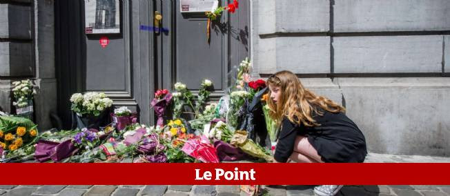 Une jeune fille dépose des fleurs sur le lieu de la fusillade, devant le Musée juif de Bruxelles, dimanche 25 mai.