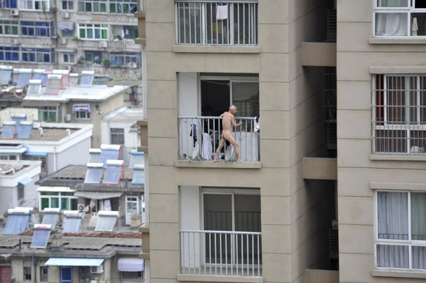 Antes da entrada da polícia, homem andou nu pendurado do lado externo da varanda do apartamento (Foto: Reuters/Stringer)