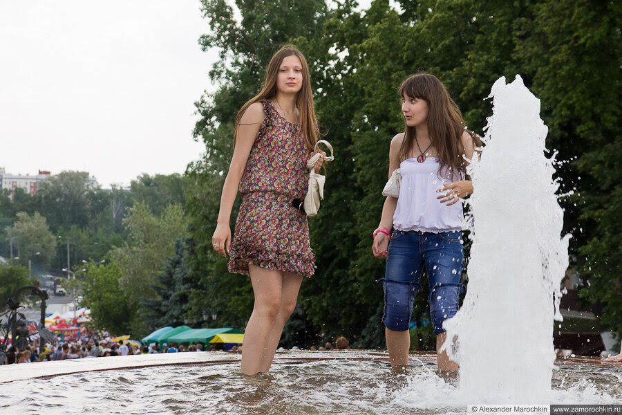Девушки в одежде купаются в фонтане