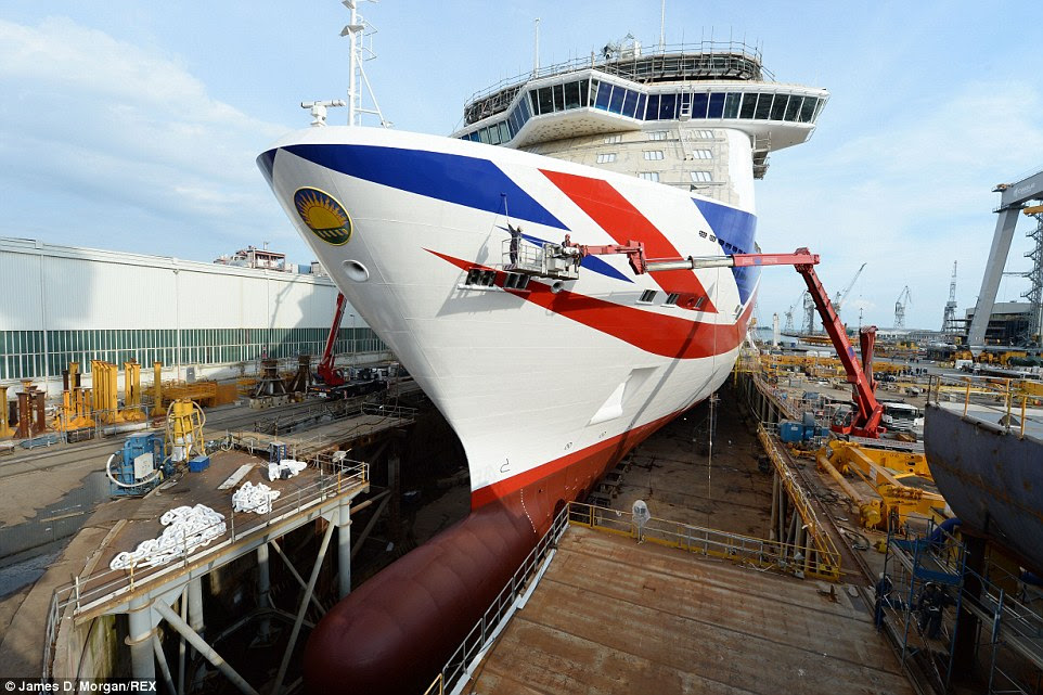 Finishing touches: Painters work on Britannia's sparkling new livery, which features the world's largest contemporary version of the Union Jack painted on the hull