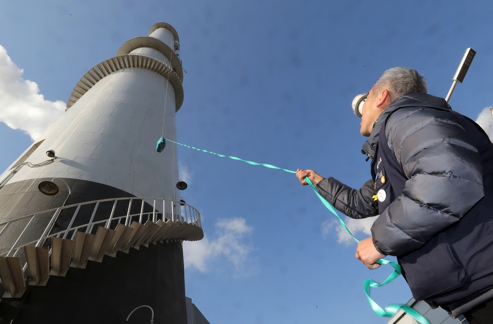 차광호 금속노조 파인텍지회장이 12월6일 서울 양천구 목동 열병합발전소 굴뚝 위로 밥과 물이 든 가방을 올리고 있다. 11월12일 고공농성을 시작한 홍기탁·박준호가 굴뚝 위에서 가방을 끌어올렸다. 강재훈 선임기자 khan@hani.co.kr