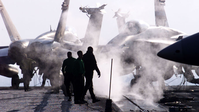 Ordnancemen aviação dos EUA caminhar ao lado de três F/A-18 Hornet no porta-aviões USS Enterprise no Mar Adriático 22 de janeiro de 1999. (Reuters)