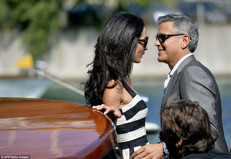 Look into my eyes: Glowing couple George Clooney and Amal Alamuddin couldn't take their eyes off each other when they sped through Venice, Italy, on Friday on taxi boats to their future wedding location
