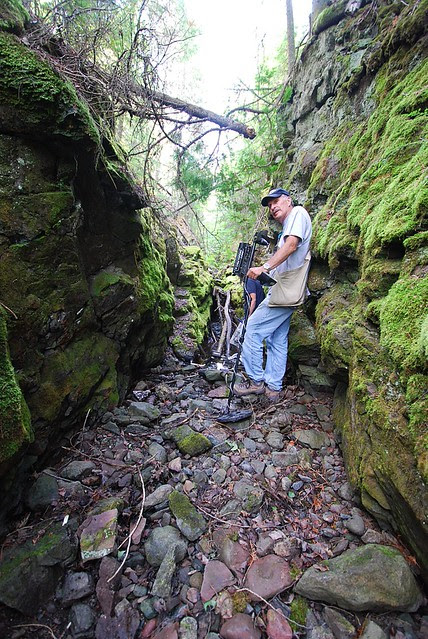 People in a narrow rocky cut, with metal detectors