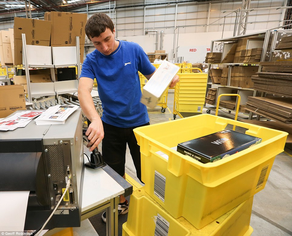 Ready: A worker packs up a Nintendo Wii console next to a stack of flyers