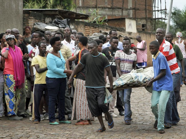 População carrega corpo no bairro de Nyakabiga em Bujumbura, no Burundi. (Foto: AP Photo)
