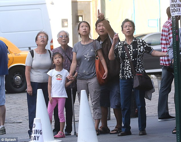 Disbelief: Tourists point at the shocking views of people using bathrooms in the hotel above