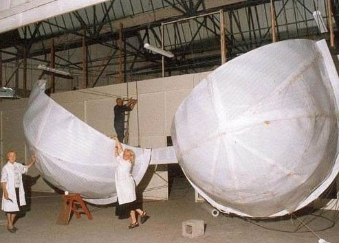 Figure of a giant bra being fabricated in a factory