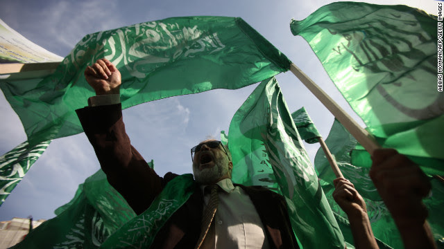 Palestinian protesters hold up the Hamas flag during a rally Friday in the West Bank city of Ramallah.