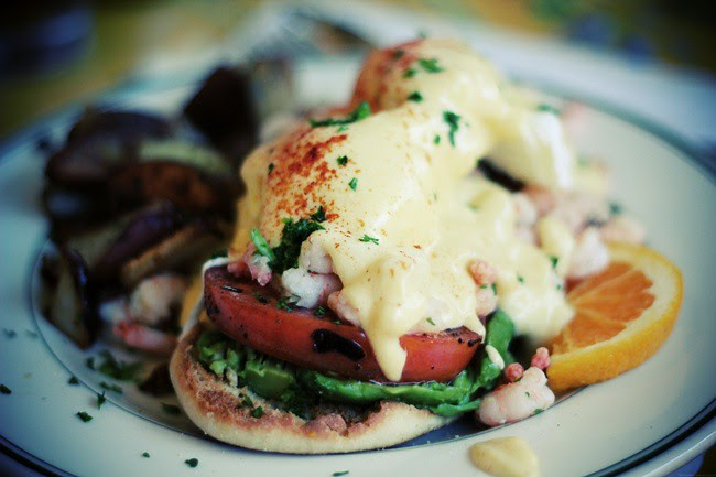 eggs benedict with shrimp, avocado and grilled tomato.