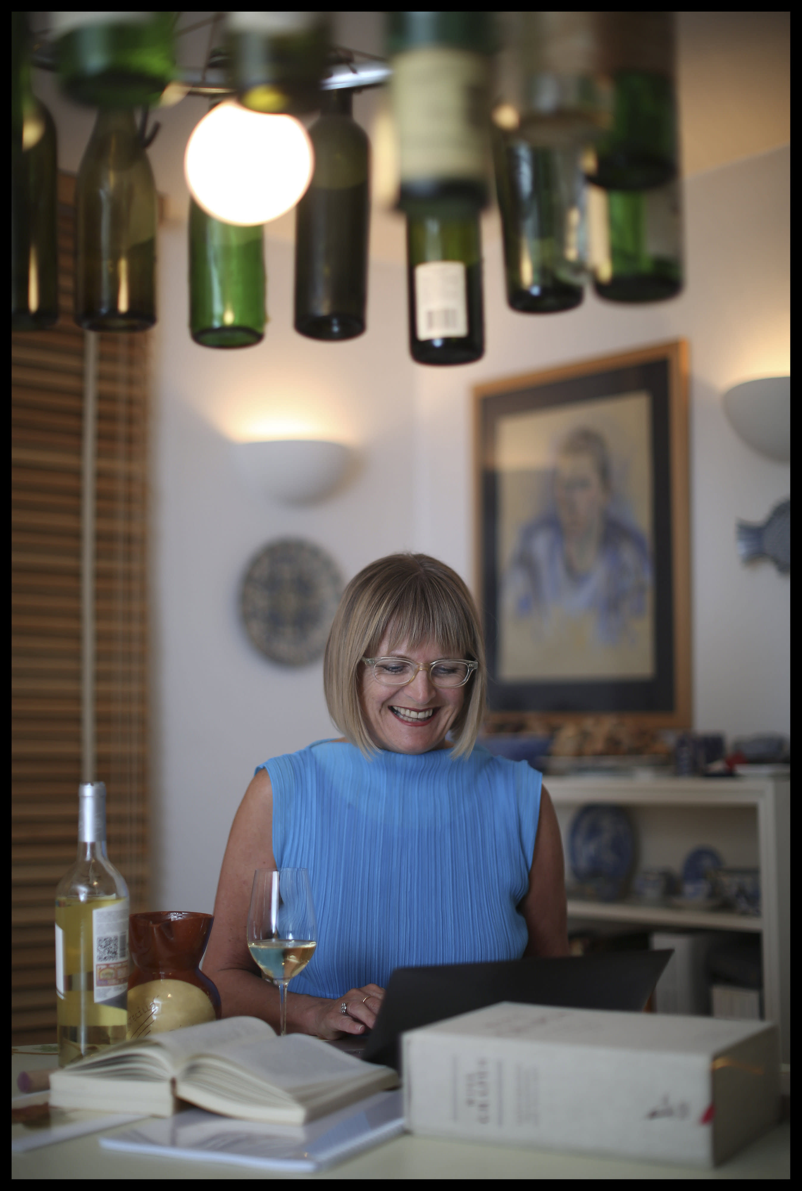 ancis Robinson at her laptop surrounding by wine bottles (courtesy)