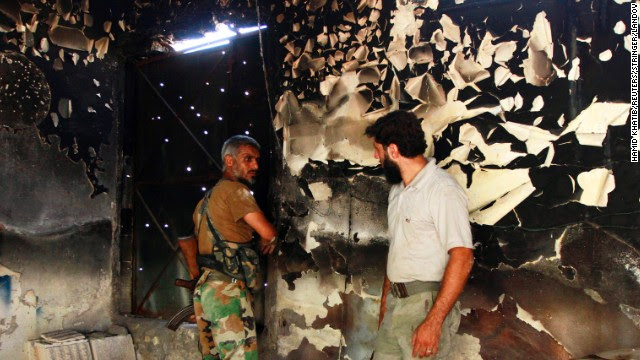 Free Syrian Army fighters talk inside a burnt house in Aleppo on September 3.