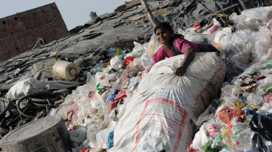 Una niña, entre montones de basura.
