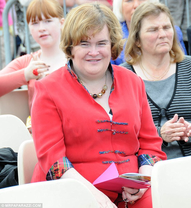 A cheerful Susan looks like just another local villager as she takes her seat at the Blackburn gala today 