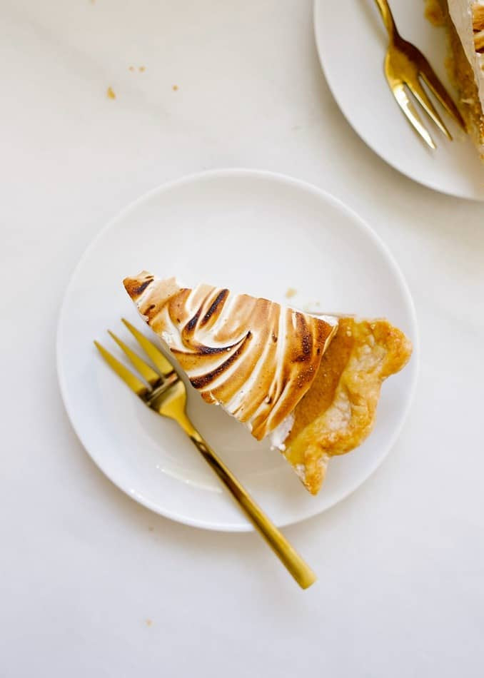 Sweet Potato Meringue Pie by Wood and Spoon blog. This is a butter and shortening pie crust blind baked and filled with a sweet potato, pumpkin tasting filling, cinnamon, and warm spices. The topping is a brown sugar and cinnamon marshmallow meringue that is cooked on the stove and whipped to stiff peaks. The whole thing is torched for a toasty golden finish. Read more about this fall autumn favorite pie for holidays (especially thanksgiving!) on thewoodandspoon.com by Kate Wood
