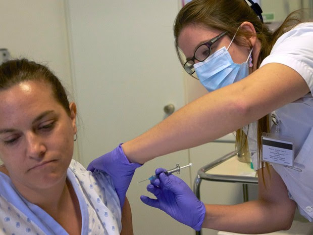 Uma enfermeira se prepara para aplicar seringa contendo uma vacina experimental contra o ebola em uma voluntária em Lausana, na Suíça (Foto: Denis Balibouse/Reuters)