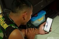 Anggota TNI sedang menghubungi keluarganya 
