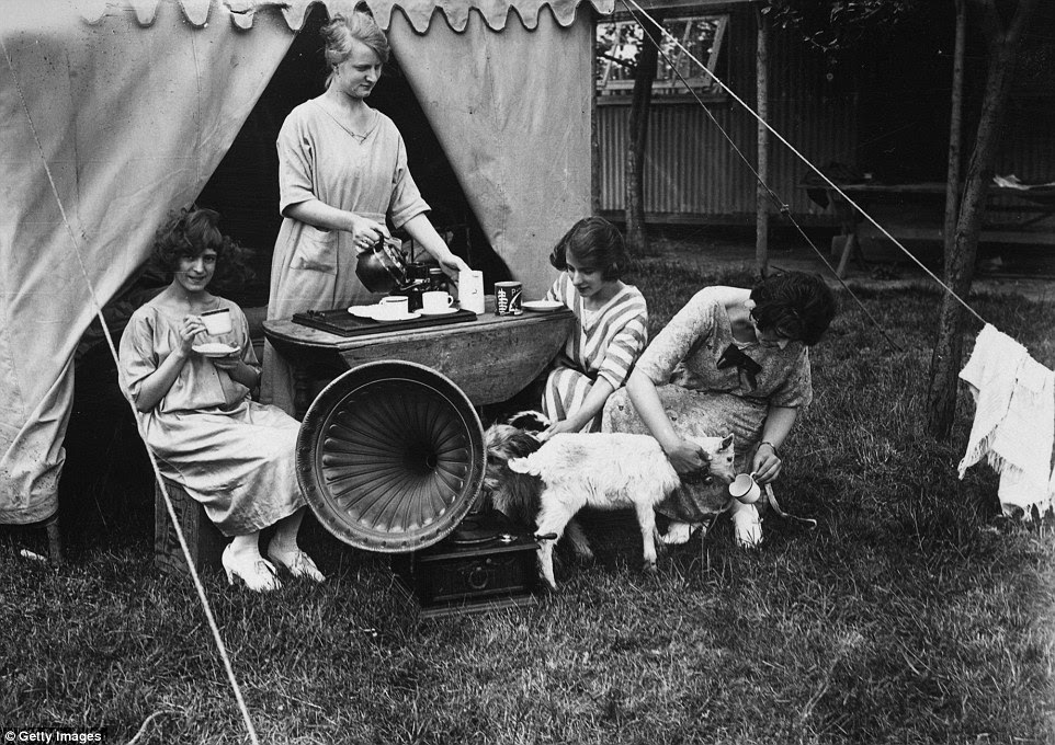 Holidaymakers listen to music at teatime outside their tent on the Chiltern Hills in southern England