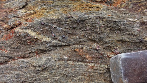 Getting closer to the garnet! Hammer tip for scale.