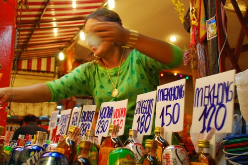  Thai woman explaining the price of various plastic punch buckets 