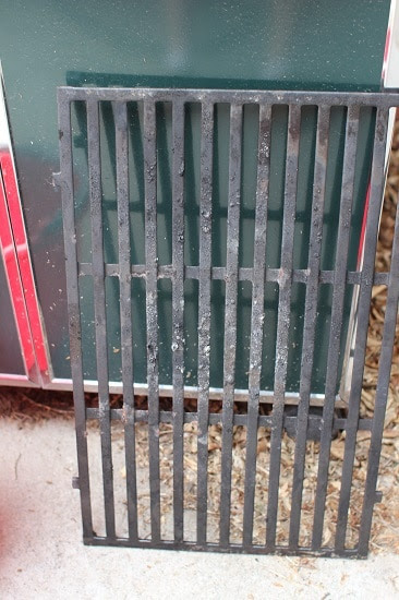 After you've brushed the top side real well, take the grates out. You'll notice the bottom needs a good scraping as well. Do so now and set them aside.