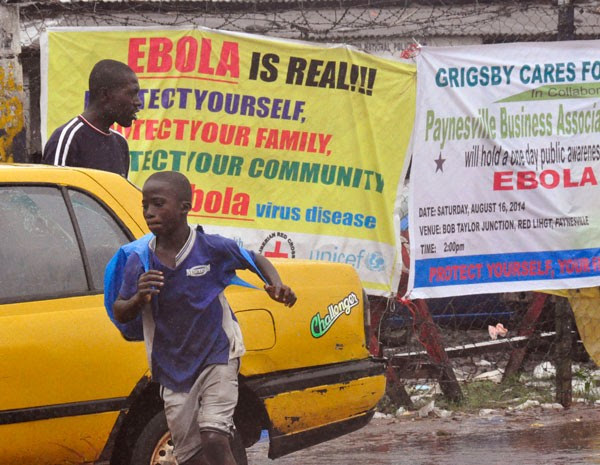 Cartazes avisam do risco de contaminação do vírus Ebola, na Libéria. (Foto: Abbas Dulleh/AP Photo)