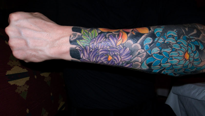 flower tattoo sleeve. a new tattoo on his arm.