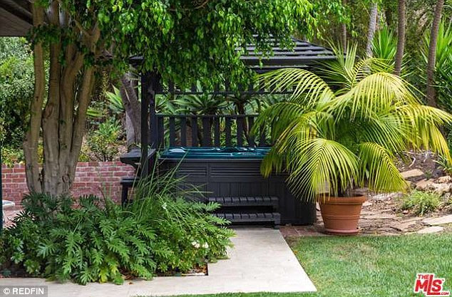 Kick back: The singer's new spot feels like it is in an enchanted forest - well an enchanted forest with a hot tub
