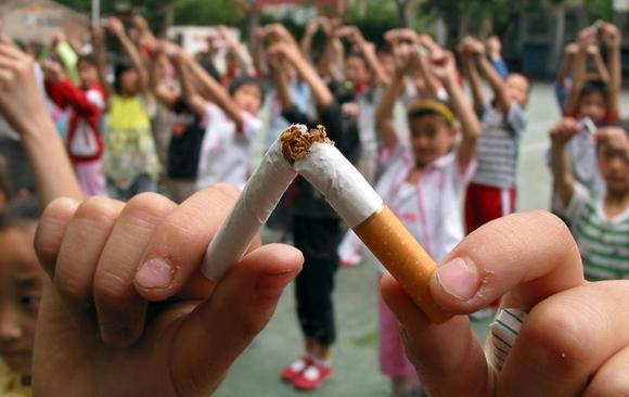 Pupils break cigarettes as a gesture showing their determinations of non-smoking at an elementary school of Jinan, the capital eastern China's Shandong province May 29, 2006. REUTERS/Stringer