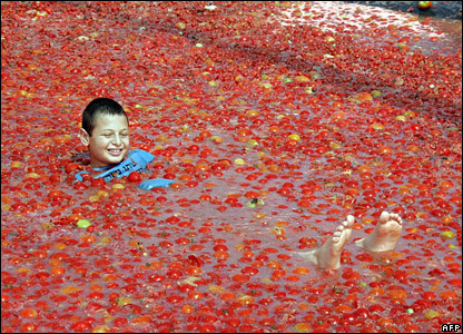 An Israeli boy splashes around in a pool of tomatoes at a tomato festival at Hevel Shalom in the western Negev region of Israel