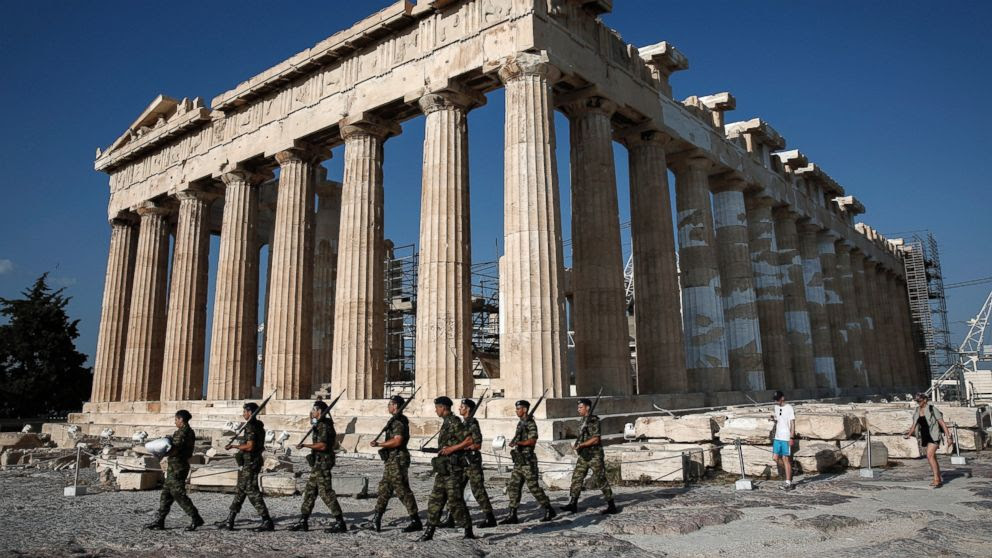 PHOTO: An army contingent carry a Greek flag in front of the Temple of the Parthenon before a hoisting ceremony at the Acropolis Hill in Athens, Greece, June 18, 2015.