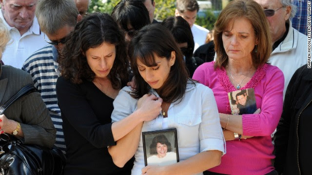 Danielle LeMack, left, Carie LeMack and Christie Coombs, who lost relatives on 9/11, pause during a ceremony to honor the victims on May 2, 2011, at the Garden of Remembrance in Boston.