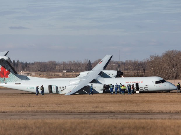 Investigadores analisam um avião de passageiros da Air Canada após pouso de emergência em Edmonton, no Canadá. O vôo 8481 saiu de Calgary, estava a caminho de Grande Prairie e transportava 71 passageiros, além de uma tripulação de quatro pessoas (Foto: Jason Franson/The Canadian Press/AP)
