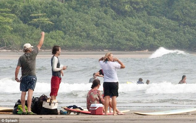 Over here: The group watched the surfers and Michael was seen gesturing to some of them 