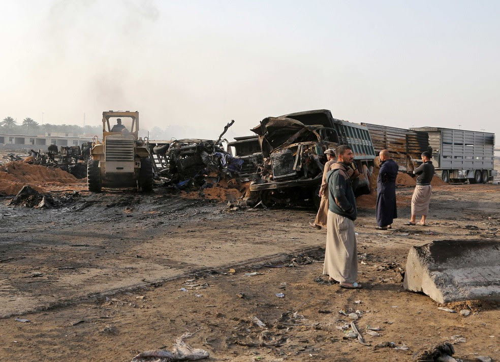 Civis inspecionam caminhão que explodiu durante ataque suicida no Sul de Bagdá, no Iraque, nesta quinta-feira (30)  (Foto: Karim Kadim/ AP)