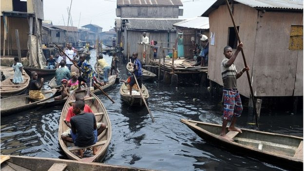 People navigate through the waterways of the Makoko slum in Lagos, Nigeria on 30 August 2012