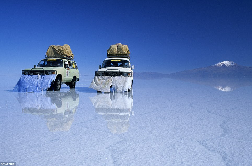 Volcanic region: The Tunupa volcano can be seen in the background  as these cars negotiate the flats