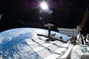 The sun shines above the Earth's horizon with the International Space Station in the foreground in this photo taken by spacewalker Ron Garan. photo