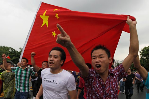 Protesters shout slogans with a Chinese national flag during an anti-Japan protest in Shenzhen, south China's Guangdong province