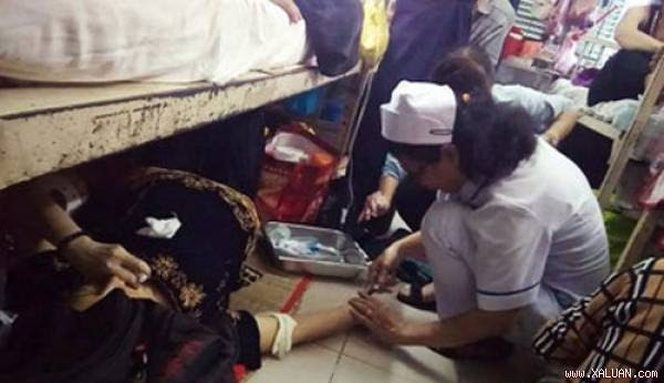 Điều dưỡng cấp cứu cho bệnh nhân ngay trên sàn nhà. Ảnh: VTCnews.