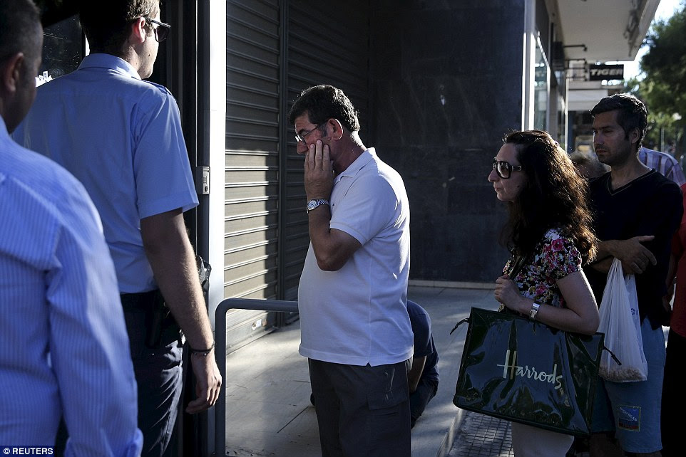 Worries: A Greek man appears deep in thought as he queues outside a bank in central Athens this morning