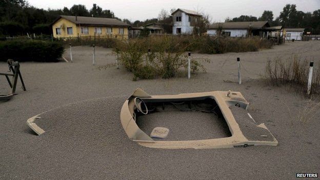 A boat is seen in a house backyard at Ensenada town which is covered with ash from Calbuco volcano near Puerto Varas city, April 23, 2015