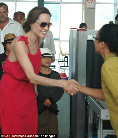 Quando se preparava para embarcar em um avião no Vietnã com seus seis filhos, Angelina moldura fina foi acentuada pelo seu vestido de largas