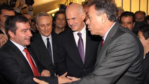 Prime Minister George Papandreou, second from right, congratulates newly elected greater Athens governor Yiannis Sgouros, right, and the city's mayor-elect Giorgos Kaminis, left, on Sunday.