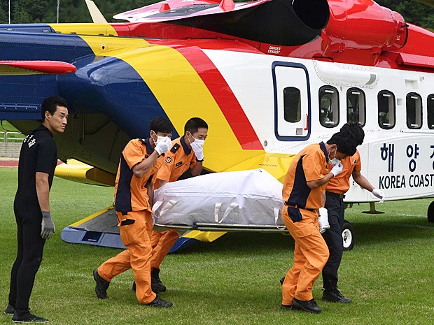Resgatistas carregam o corpo de uma das vítimas do naufrágio do pesqueiro na Coreia do Sul (Foto: Ryu Hyung-geun/Newsis via AP)