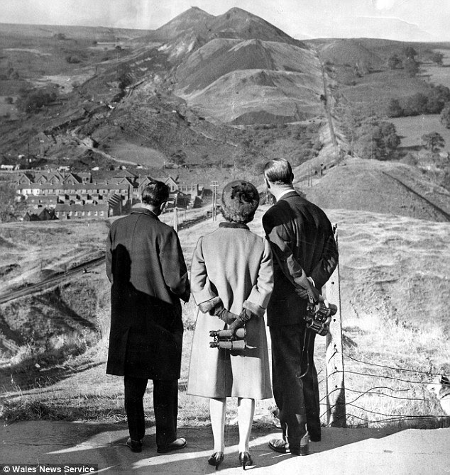 Paying their respects: The Queen and Duke of Edinburgh look towards the landslide during their visit in 1966 after the disaster