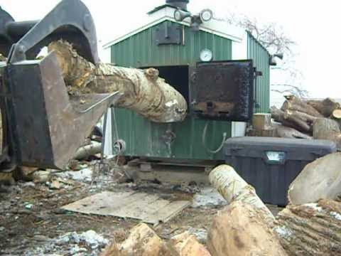 loading outdoor wood boiler with a skid loader